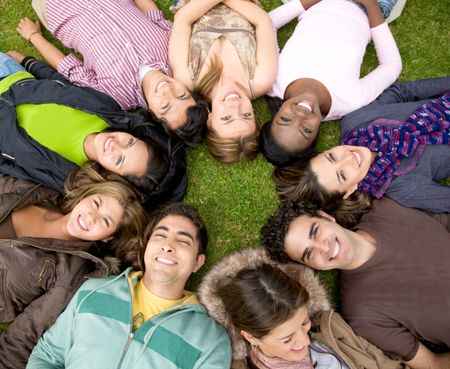 group of friends or college students outdoors with heads together