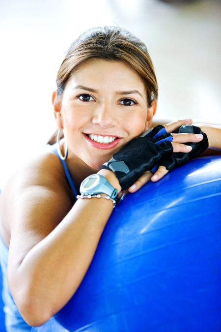 gym woman doing pilates exercises on a blue ball