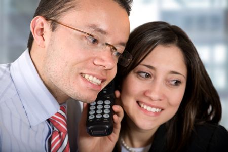 Business partners in their office listening to good news on the phone