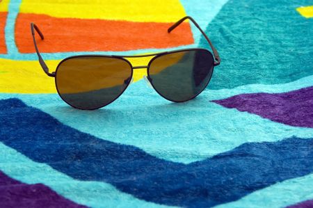 Aviator sunglasses on beach towel