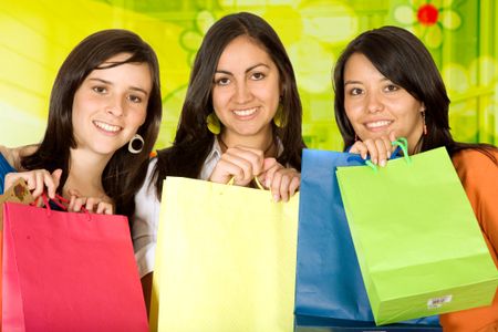 girls with shopping bags in front of a green glass background