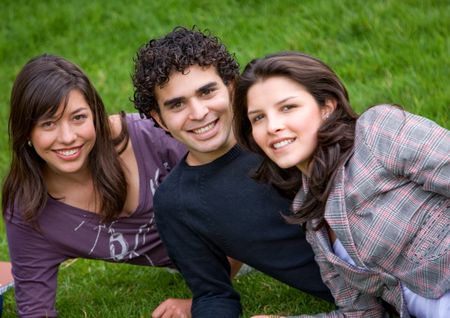 friends or university students smiling outdoors in a park