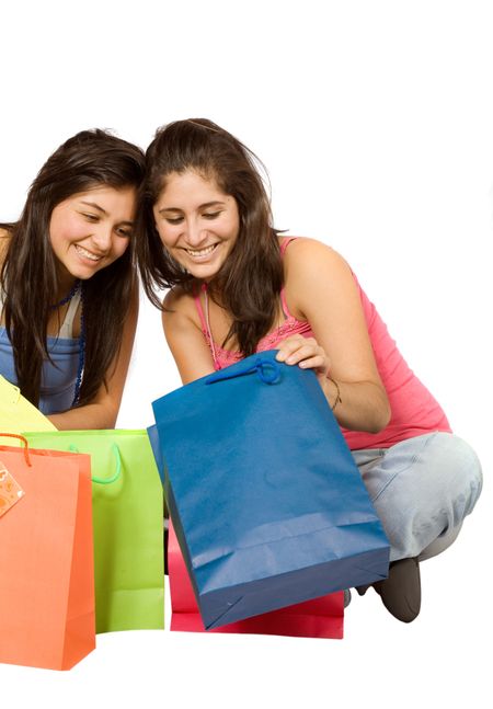 beautiful girls looking at their shopping over a white background