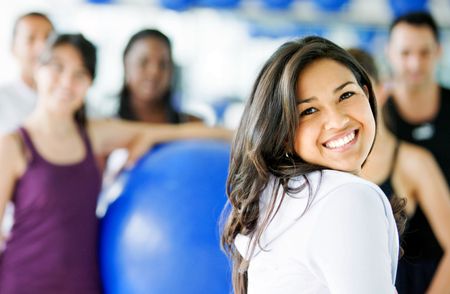 happy woman at the gym smiling in front of a group