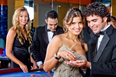 elegant couple at the casino smiling and betting on the roulette