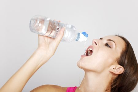 Young woman drinking from a water bottle after a long workout