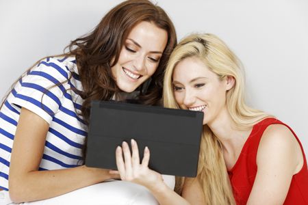 Two young friends using a computer tablet together