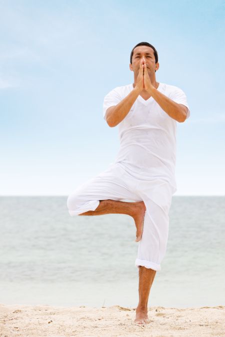 beach man in a yoga position meditating