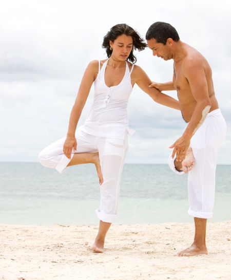 class of yoga at the beach - couple
