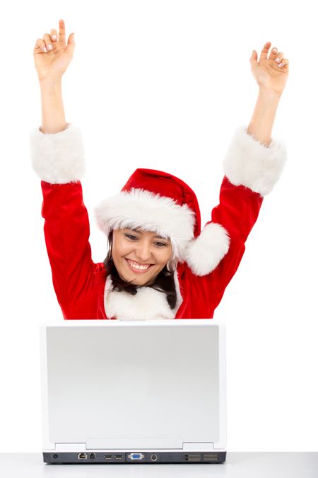 Christmas girl happy with her success while working on a laptop - isolated over a white background
