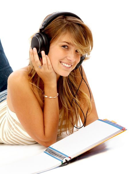 Casual student listening to music while studying isolated over a white background