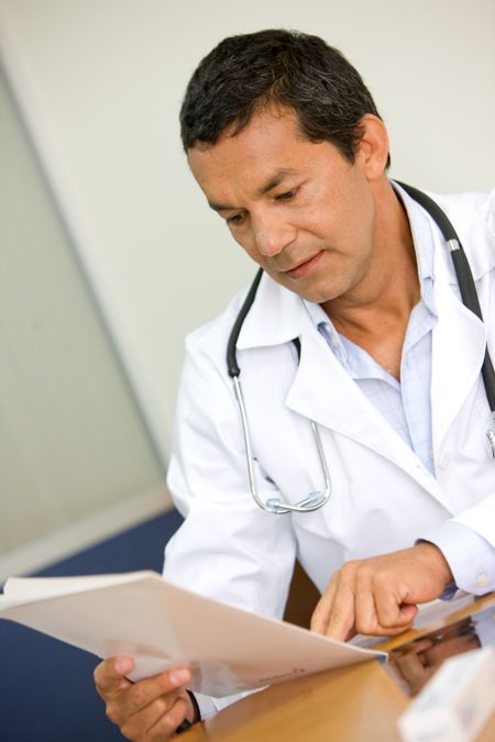 senior male doctor in a hopistal looking at a piece of paper