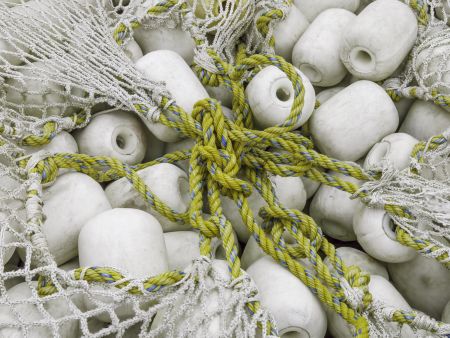Industrial togetherness: White floats of commercial fishing net, with yellow and blue line for cinch on top