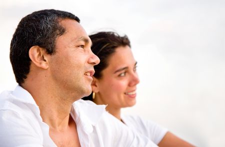 couple looking away at the beach and smiling