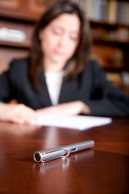business woman in an office with a fountain pen by her