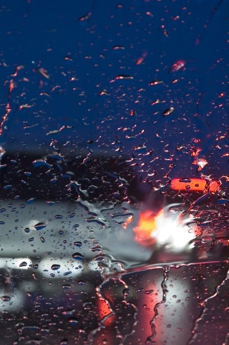 Rear of car seen through windshield in rain