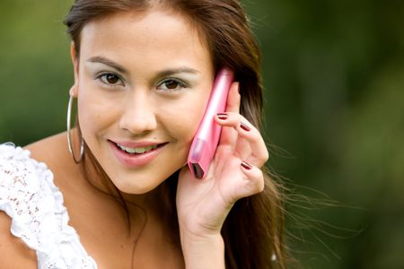 casual woman talking on the phone - smiling outdoors