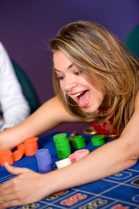 woman in a casino gambling and winning on the roulette