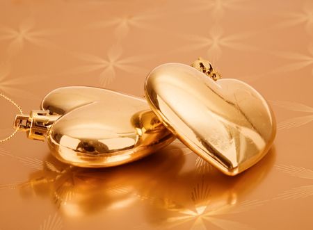 couple of golden hearts on a golden background