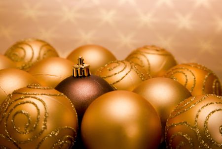 golden christmas baubles with one standing out of the pack