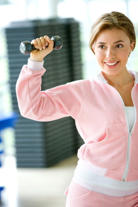 beautiful woman at the gym exercising with small free weights