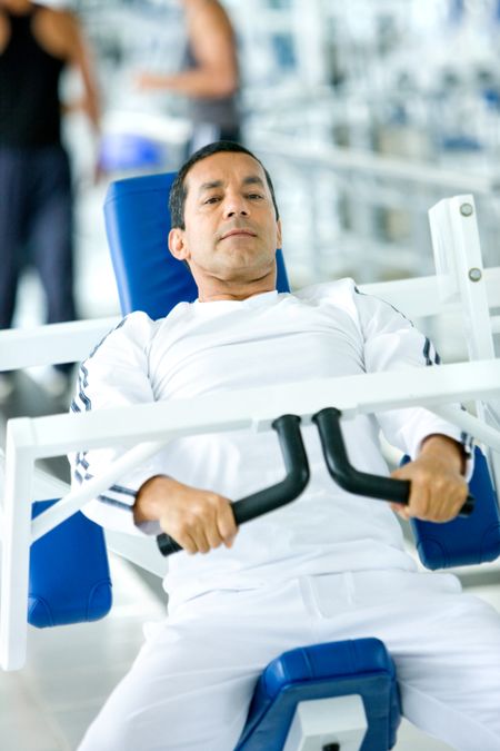 man at the gym doing exercises on a machine