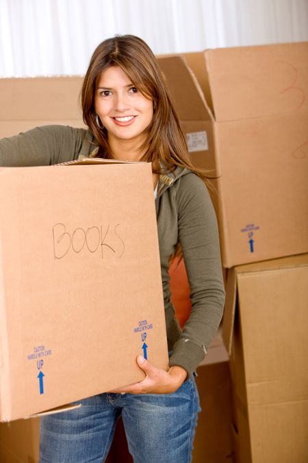 Beautiful woman moving house and carrying boxes