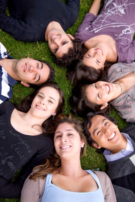 happy group of friends together on the floor outdoors