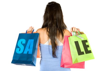 girl with shopping bags from behind with the word sale on the bags over white background