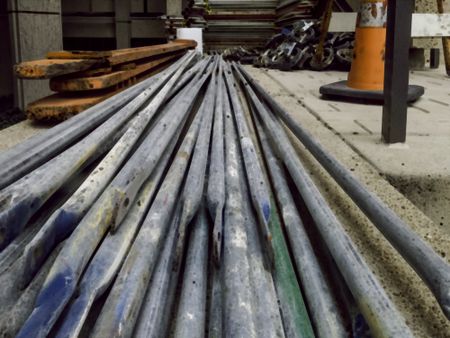 Abstract illustration of long steel bars and other equipment for assembly of scaffolding on a construction site