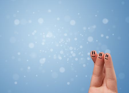 Happy finger smileys faces on hand with empty blue bokeh background