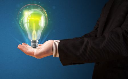 Businessman holding glowing lightbulb in his hand