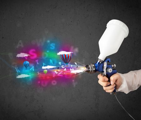 Worker with airbrush and colorful abstract clouds and balloons concept