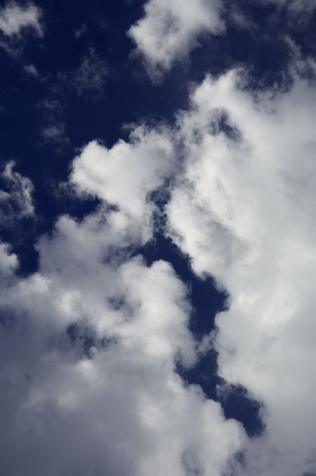 Rift in cumulus clouds in blue sky