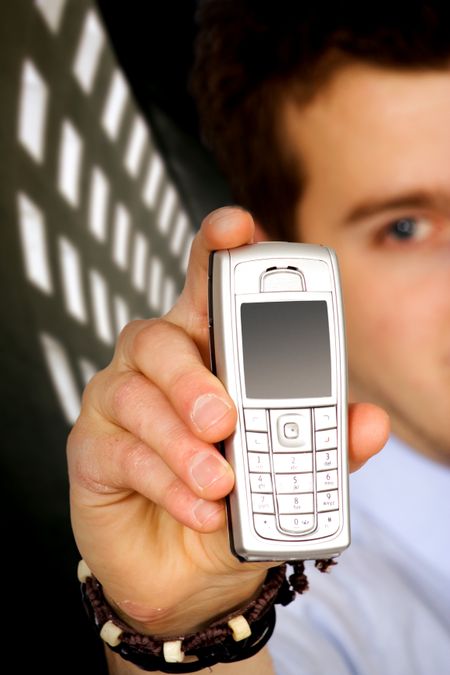 business man holding a mobile phone over a dark background