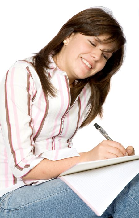 girl smiling while making notes on her notebook over a white background