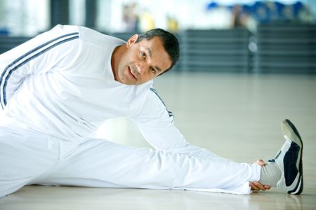 Man at the gym doing stretching exercises
