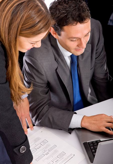 Business couple working on a laptop isolated over white