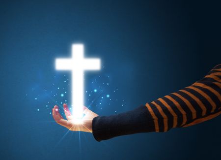 young-woman-holding-glowing-cross-hand-232345660 Young woman holding a glowing cross in her hand