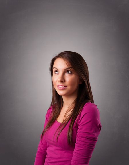 Beautiful young woman standing and thinking with copy space