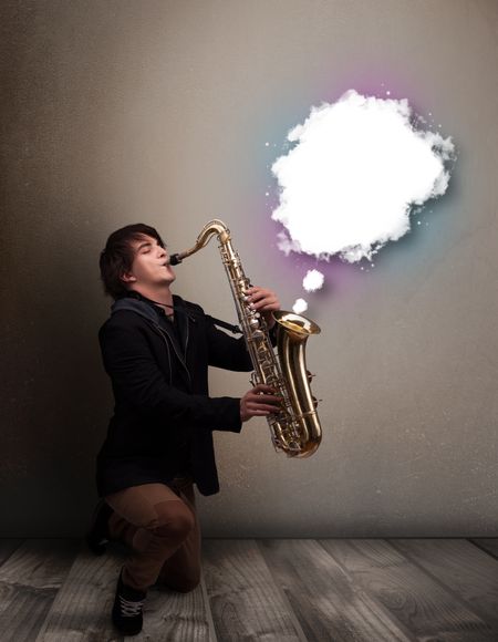 Handsome young man playing on saxophone with copy space in white cloud