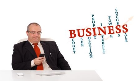 businessman sitting at desk and holding a mobilephone with business word cloud, isolated on white