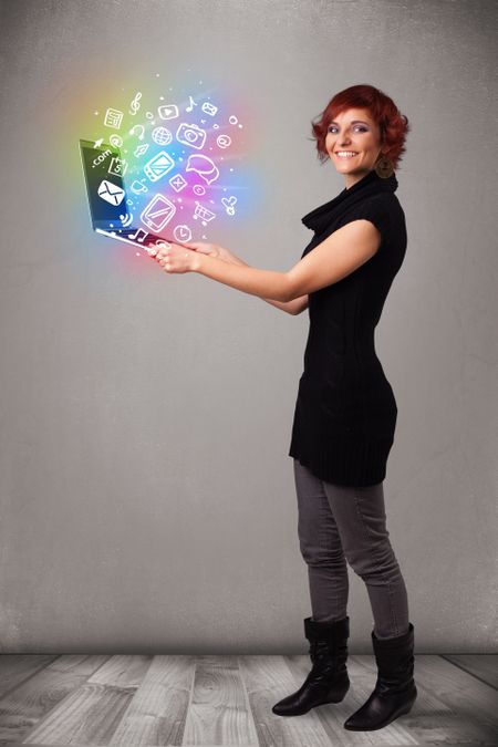 Beautiful young woman holding notebook with colorful hand drawn multimedia icons