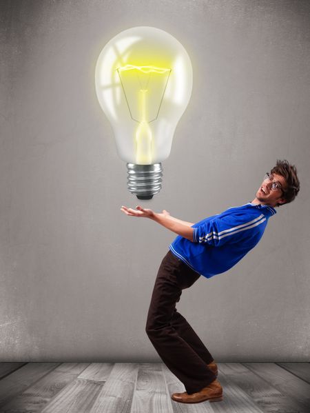 Attractive young man holding realistic 3d light bulb