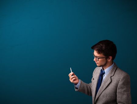 Handsome young man smoking cigarette with copy space