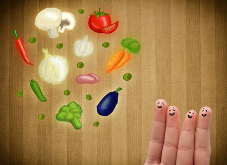 Happy smiley face fingers cheerfully looking at illustration of colorful healthy vegetables