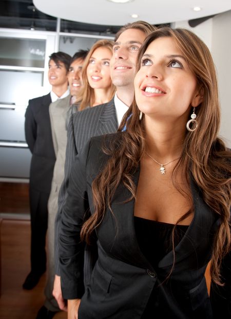 group of business people in a row looking up in an office