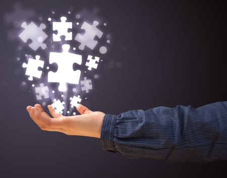 Woman holding shining puzzle pieces in her hand