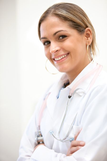 friendly female doctor smiling with her arms crossed in a hospital