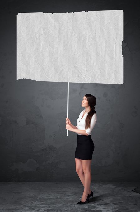Young businesswoman holding a big blank booklet paper 